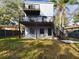 Rear exterior shot featuring the second-story wooden deck, a concrete patio, and a small grassy yard at 1793 N Fort Harrison Ave, Clearwater, FL 33755