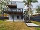 Rear exterior view of the home featuring upper and lower decks, stairs and a concrete patio at 1793 N Fort Harrison Ave, Clearwater, FL 33755
