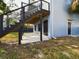 Exterior shot features a concrete patio, stairs to the deck and a doorway to the lower level at 1793 N Fort Harrison Ave, Clearwater, FL 33755