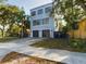 Modern three-story home with a two-car garage, concrete driveway and manicured lawn at 1793 N Fort Harrison Ave, Clearwater, FL 33755