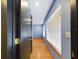 Well-lit hallway with hardwood floors leads to a blue room with windows at 1793 N Fort Harrison Ave, Clearwater, FL 33755