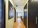 Hallway with wood floors leads past doors and an art print to a room with natural light at 1793 N Fort Harrison Ave, Clearwater, FL 33755
