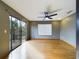A living room has a ceiling fan, glass doors to a patio and a large window for lots of light at 1793 N Fort Harrison Ave, Clearwater, FL 33755