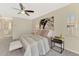 A serene main bedroom boasts a neutral palette, ceiling fan, and a window with plantation shutters at 2302 De Garmo St, North Port, FL 34291