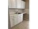 Kitchen area with white cabinets and stainless steel sink at 2505 Warne St, Port Charlotte, FL 33952