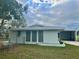 Side view of the home showing the carport, fenced-in backyard, and impact windows at 2585 Ednor St, Port Charlotte, FL 33952