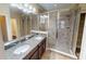 Bathroom with double sink vanity, granite counters and a glass enclosed shower offering luxury and convenience at 5406 Fishhawk Ridge Dr, Lithia, FL 33547
