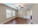 Comfortable bedroom featuring wood floors, a ceiling fan, and bright windows allowing natural light at 5406 Fishhawk Ridge Dr, Lithia, FL 33547
