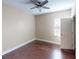 Neutral bedroom featuring hardwood floors, a ceiling fan, and a large window for natural light at 5406 Fishhawk Ridge Dr, Lithia, FL 33547