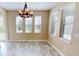 Bright dining area with new floors, three windows, and modern chandelier at 5406 Fishhawk Ridge Dr, Lithia, FL 33547