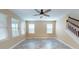 Spacious living room with wood floors, ceiling fan and multiple windows for natural light at 5406 Fishhawk Ridge Dr, Lithia, FL 33547