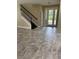 Open-concept living area with staircase and stylish floors flowing to the bright glass double door entrance at 5406 Fishhawk Ridge Dr, Lithia, FL 33547