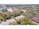 An aerial view shows multi-Gathering homes surrounded by trees near a road and other commercial buildings at 8418 Sandy Beach St, Tampa, FL 33634