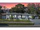 Charming single-story home with a well-maintained lawn and mature trees at sunset at 12723 Pecan Tree Dr, Hudson, FL 34669