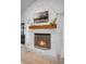 Close-up on brick fireplace featuring a wooden mantle, a metal screen, and sliding glass doors to the backyard at 12723 Pecan Tree Dr, Hudson, FL 34669