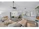 Bright open-concept living room with ceiling fan flowing into the dining and kitchen areas at 12723 Pecan Tree Dr, Hudson, FL 34669