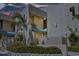Exterior of a tan condo building with lush landscaping and a well-maintained facade at 722 Pinellas Bayway S # 102, St Petersburg, FL 33715