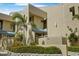 Exterior of a tan condo building with lush landscaping and a well-maintained facade at 722 Pinellas Bayway S # 102, St Petersburg, FL 33715