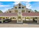 Exterior view of a condo building featuring covered parking, mature landscaping, and a well-maintained facade at 722 Pinellas Bayway S # 102, St Petersburg, FL 33715