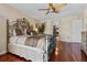 Main bedroom with hardwood floors, large bed, ceiling fan, and neutral colors at 722 Pinellas Bayway S # 102, St Petersburg, FL 33715