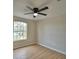 Bedroom with wood floors and a large window providing lots of natural light and a ceiling fan at 11606 Tropical Isle Ln, Riverview, FL 33579