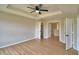 Spacious main bedroom featuring wood flooring, a tray ceiling and a view of the walk-in closet at 11606 Tropical Isle Ln, Riverview, FL 33579