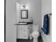 Bathroom with a white vanity with a sink, toilet, and a blue nautical themed hand towel at 764 S Mccall Rd, Englewood, FL 34223