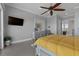 Bright bedroom with a large TV, ceiling fan, and a comfortable yellow comforter at 764 S Mccall Rd, Englewood, FL 34223