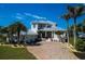 Beautiful two-story home with a gray metal roof, paver driveway, and meticulously landscaped grounds at 764 S Mccall Rd, Englewood, FL 34223
