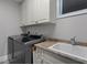 Modern laundry area boasting front-load washer/dryer and granite countertop over cabinets with sink at 764 S Mccall Rd, Englewood, FL 34223