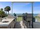 Outdoor kitchen and dining area with a built-in grill and countertop space, overlooking the ocean at 764 S Mccall Rd, Englewood, FL 34223
