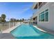 A long swimming pool surrounded by a patio, landscaping, and a white fence at 764 S Mccall Rd, Englewood, FL 34223
