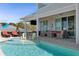 An outdoor pool with a tanning ledge, lounge chairs, and an outdoor TV with covered seating at 764 S Mccall Rd, Englewood, FL 34223