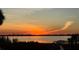 Waterfront view of vibrant sunset featuring orange skies, tranquil waters, and lush greenery in a serene outdoor setting at 764 S Mccall Rd, Englewood, FL 34223