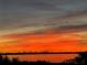 Waterfront sunset reflecting vibrant oranges, silhouetted trees, tranquil waters, and colorful skies at 764 S Mccall Rd, Englewood, FL 34223