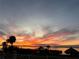 Waterfront sunset with tranquil water, colorful clouds, palm trees, lush greenery, and a charming tiki hut at 764 S Mccall Rd, Englewood, FL 34223