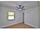 Bright bedroom with a ceiling fan, a window, and wood-look flooring, showcasing neutral color palette at 3212 Cork Rd, Plant City, FL 33565