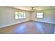 Spacious living room with wood flooring, large windows, and modern ceiling fan at 3212 Cork Rd, Plant City, FL 33565