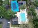 Aerial shot of tennis courts, racquetball courts, and a community pool surrounded by trees at 14663 Norwood Oaks Dr # 103, Tampa, FL 33613