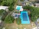 Aerial showcasing tennis courts, racquetball courts, and a community pool surrounded by trees at 14663 Norwood Oaks Dr # 103, Tampa, FL 33613