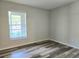 Bedroom with modern laminate flooring and a large window that lets in natural light at 14663 Norwood Oaks Dr # 103, Tampa, FL 33613