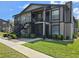 Two-story condo with an exterior staircase, screened in patio, and landscaping at 14663 Norwood Oaks Dr # 103, Tampa, FL 33613