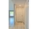 Hallway with tile flooring leading to a brightly lit living area through an open doorway at 14663 Norwood Oaks Dr # 103, Tampa, FL 33613