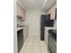 Efficient kitchen layout with black appliances, neutral cabinets, and tile flooring at 14663 Norwood Oaks Dr # 103, Tampa, FL 33613