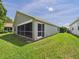 Exterior rear view of home featuring screened patio and grassy yard at 10169 Holly Berry Dr, Weeki Wachee, FL 34613