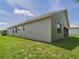 Lush green backyard with a screened in porch, and a stucco wall at 10169 Holly Berry Dr, Weeki Wachee, FL 34613