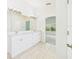 Bright bathroom with a double sink vanity, decorative lights and a doorway that leads to a bedroom at 10169 Holly Berry Dr, Weeki Wachee, FL 34613