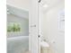 View of a white half bathroom leading to a bedroom with a vaulted ceiling and a sunlit window at 10169 Holly Berry Dr, Weeki Wachee, FL 34613
