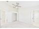 Large carpeted bedroom with a closet, doorways and a ceiling fan, illuminated by natural light at 10169 Holly Berry Dr, Weeki Wachee, FL 34613