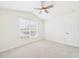Bedroom with neutral carpet, vaulted ceiling with fan, and a bright window at 10169 Holly Berry Dr, Weeki Wachee, FL 34613